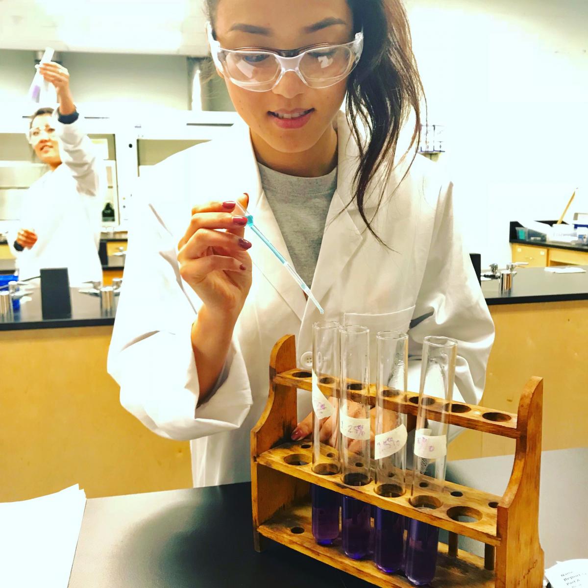 Nursing post-bac student using a dropper in the chemistry lab