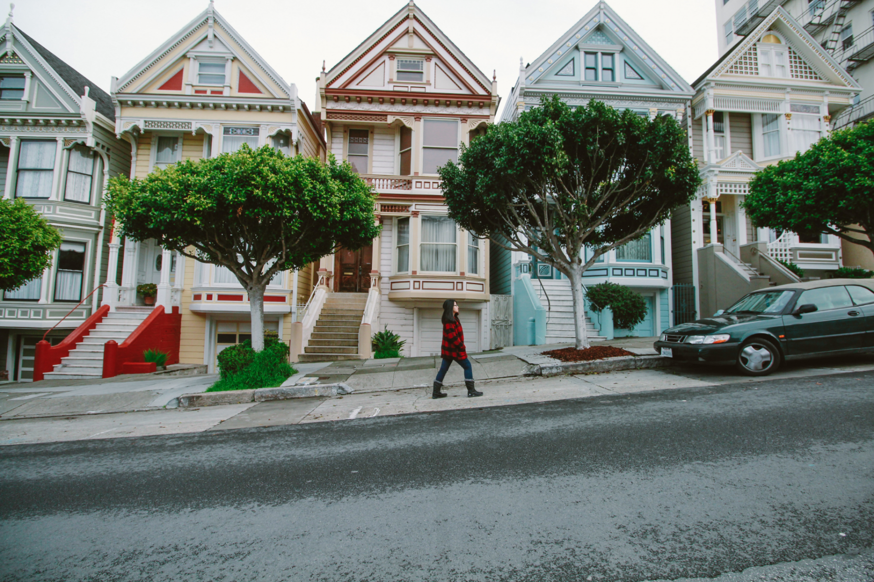 A woman walks uphill past the Painted Ladies in San Francisco