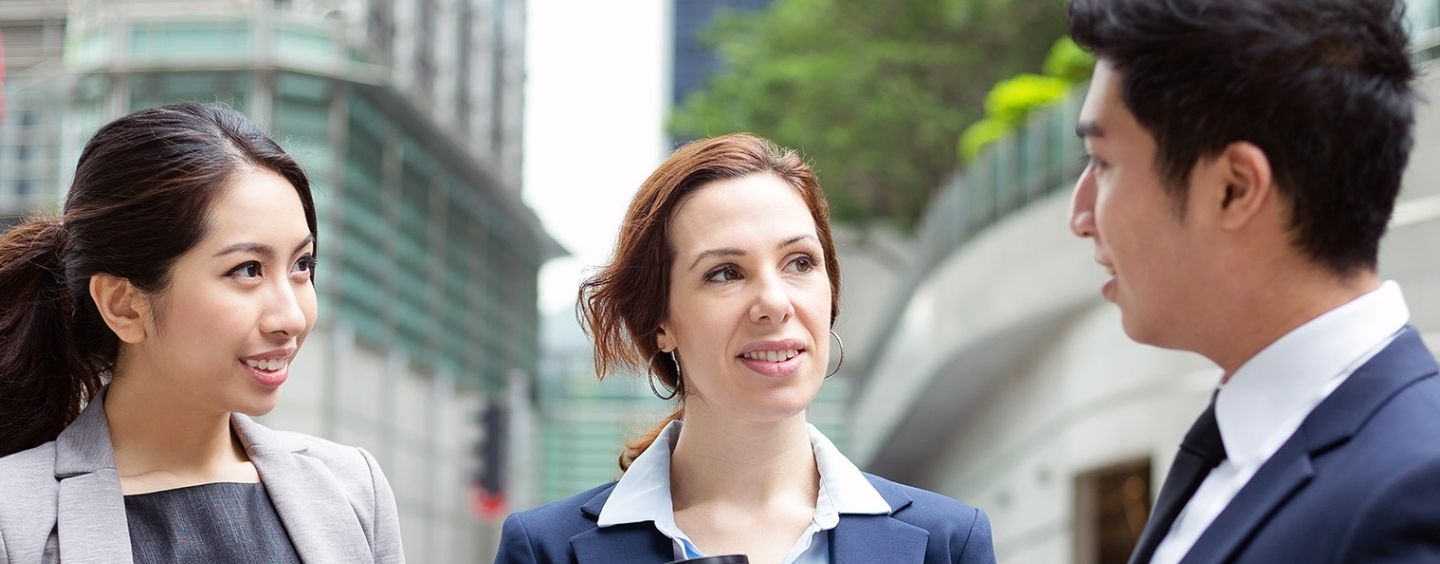 Trio of global businesspeople talking outside 