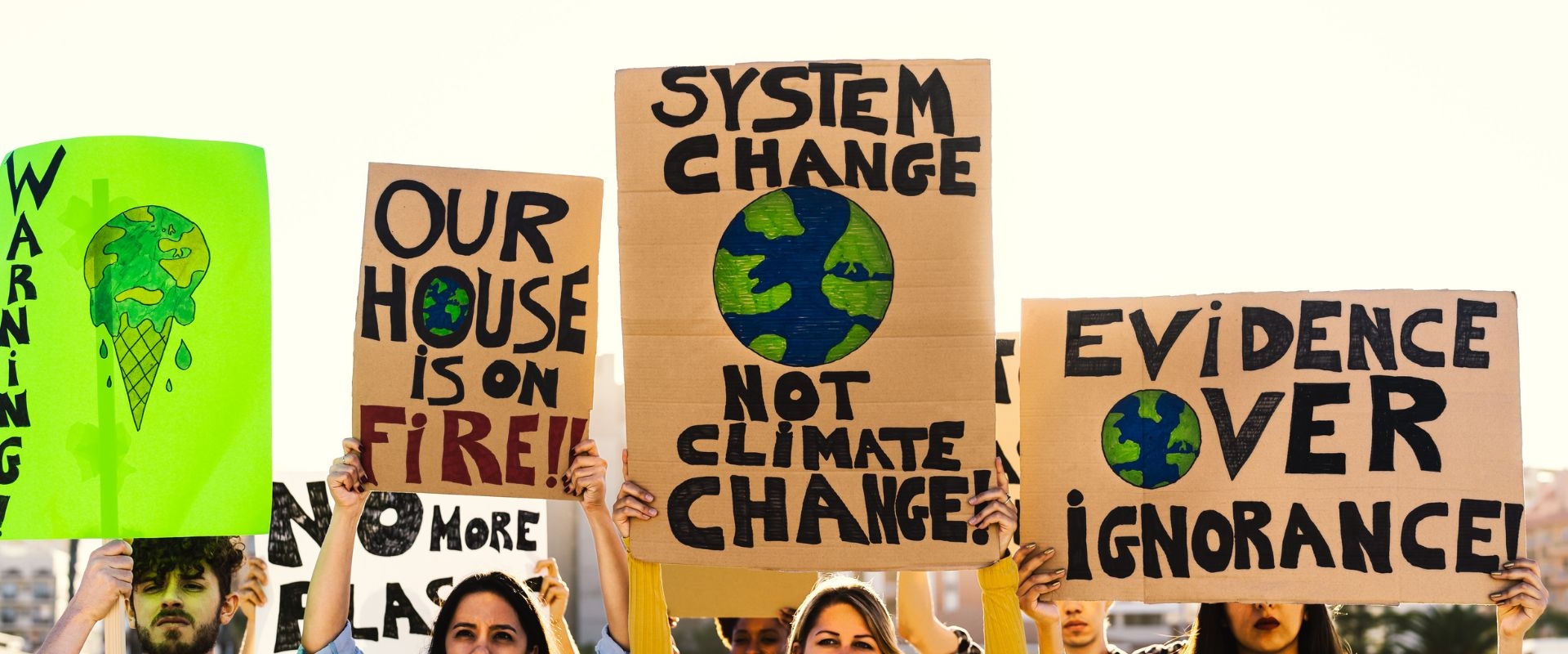 Climate justice protesters hold up signs