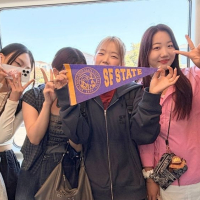 International students ride Muni and hold up an SFSU pennant