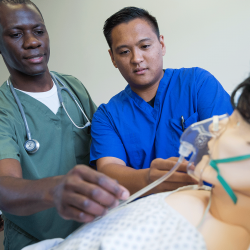 Two nursing students practice administering oxygen