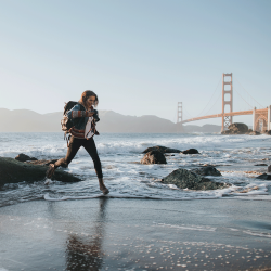 International student on a beach, with the Golden Gate Bridge in the background