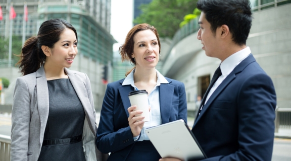 Trio of international businesspeople talking on the street