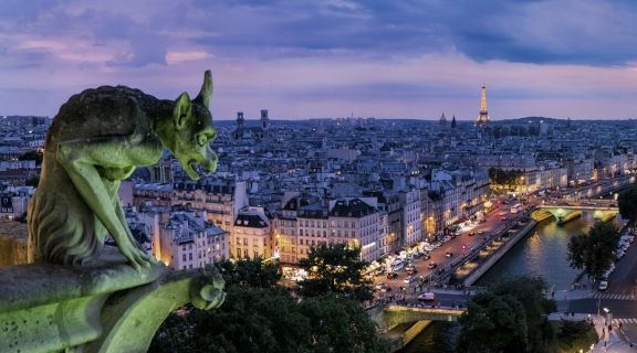 A green gargoyle over a purple Paris night sky