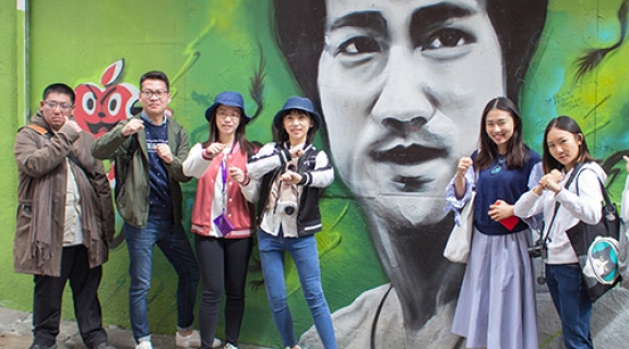 International students pose at the Bruce Lee mural.