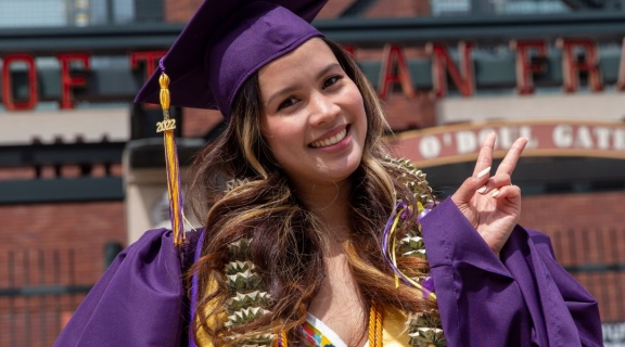 Graduate in regalia washed a peace sign